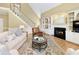 Inviting living room featuring a fireplace, built-in shelving, a staircase, and hardwood floors topped with an ornate rug at 325 N Saint Phillip Ln, Alpharetta, GA 30022