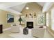 Bright main bedroom showcases a fireplace, multiple windows, a tray ceiling, and cozy seating around the hearth at 325 N Saint Phillip Ln, Alpharetta, GA 30022