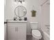 Bright bathroom with round mirror, granite counters, white cabinets and modern fixtures at 7244 Valley Dr, Winston, GA 30187