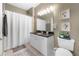 Neutral-toned bathroom features a white vanity with a dark countertop, a toilet, a shower-tub combo, and a decorative mirror at 10 Perimeter Summit Ne Blvd # 2110, Brookhaven, GA 30319