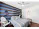 Bright bedroom with blue accent wall, featuring wood accents, a large window, and a cozy striped bed at 10 Perimeter Summit Ne Blvd # 2110, Brookhaven, GA 30319