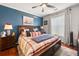 A primary bedroom showcases a king bed, fan, and a striking blue accent wall adorned with nautical-themed décor at 10 Perimeter Summit Ne Blvd # 2110, Brookhaven, GA 30319