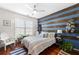 Stylishly decorated bedroom with a wooden accent wall and a cozy striped comforter at 10 Perimeter Summit Ne Blvd # 2110, Brookhaven, GA 30319