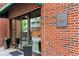 Entrance to Centennial House; brick facade with sign and decorative plants at 115 W Peachtree Nw Pl # 304, Atlanta, GA 30313
