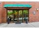 Building entrance with decorative plants and glass doors under a green awning at 115 W Peachtree Nw Pl # 304, Atlanta, GA 30313