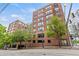 Brick apartment building with mature trees and manicured landscaping on a sunny day at 115 W Peachtree Nw Pl # 304, Atlanta, GA 30313