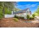 A fenced backyard with a pathway leading to the home, surrounded by pine straw and trees at 1164 Britley Park Ln, Woodstock, GA 30189