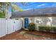 View of blue front door with a white fence and landscaping around the home at 1164 Britley Park Ln, Woodstock, GA 30189
