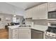 Bright kitchen with view to dining area, stainless appliances, and white cabinets at 1164 Britley Park Ln, Woodstock, GA 30189