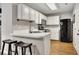 Well-lit kitchen features white cabinets, black refrigerator, and breakfast bar seating at 1164 Britley Park Ln, Woodstock, GA 30189