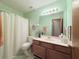 Bathroom with a shower and tub, toilet, vanity with sink and wood cabinets, a mirror, and light at 1552 Longwood Dr, Lawrenceville, GA 30043