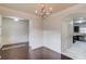 Dining room with chandelier, wainscoting and hardwood flooring, open to other rooms at 2045 Villa Spring Ct, Dacula, GA 30019