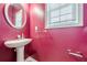 Powder room with a pedestal sink, a window, and bright pink walls at 2470 Cordillo Dr, Dacula, GA 30019