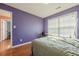A bedroom with wood floors, a window with blinds, and purple walls at 2470 Cordillo Dr, Dacula, GA 30019