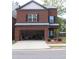 Two-story brick home with a two-car garage and small front yard featuring nice landscaping at 4265 Almanor Cir, Norcross, GA 30071