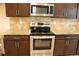 Stainless steel appliances, including an oven and microwave, are integrated into wooden cabinetry at 4265 Almanor Cir, Norcross, GA 30071