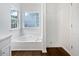 Bright bathroom featuring a soaking tub under a window and a separate shower with white tile at 100 Chartres St, Dallas, GA 30157