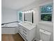 Bathroom features a double vanity, garden tub with a blue tiled backsplash, and a window at 2021 Emerald Dr, Loganville, GA 30052