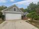 Gray home featuring a two-car garage, manicured front yard, and walkway to the front door at 2021 Emerald Dr, Loganville, GA 30052
