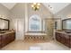 Bathroom featuring a soaking tub, a chandelier, granite counters, and tile floors at 315 Stanyan Pl, Alpharetta, GA 30022