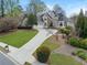 Charming home with manicured lawn, mature landscaping, stone accents, and three-car garage at 315 Stanyan Pl, Alpharetta, GA 30022