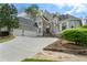 Two-story home featuring stone and stucco facade, three-car garage, and well-manicured landscaping at 315 Stanyan Pl, Alpharetta, GA 30022