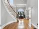 Grand foyer featuring hardwood floors, a curved staircase, and a double-door entry with transom window at 315 Stanyan Pl, Alpharetta, GA 30022