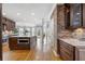 Open kitchen with a large island, custom cabinets, brick accent wall, and hardwood floors at 315 Stanyan Pl, Alpharetta, GA 30022