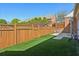 A fenced backyard features manicured artificial turf and backs to mature trees at 132 Westchester Se Dr, Smyrna, GA 30082