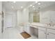 Bright bathroom with double vanity sinks, large mirror, tiled floor, soaking tub, and recessed lights at 132 Westchester Se Dr, Smyrna, GA 30082