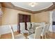 Elegant dining room with a glass table, seating for six, and traditional wainscoting and crown molding at 132 Westchester Se Dr, Smyrna, GA 30082