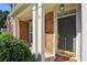 Close-up of a classic front door with white trim, a small porch, and lush green landscaping at 132 Westchester Se Dr, Smyrna, GA 30082