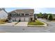 A large brick townhome features a three-car garage, well-manicured lawn, and attractive landscaping at 7200 Brigidoon Rose, Douglasville, GA 30134