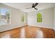 Bright bedroom with hardwood floors, three windows, ceiling fan, and white trim at 78 Beverly Ne Rd, Atlanta, GA 30309