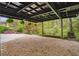 Carport with gravel, hanging ferns, a firewood rack, and a greenery backdrop at 78 Beverly Ne Rd, Atlanta, GA 30309