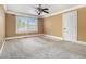 A neutral bedroom features a ceiling fan, white trim, and a window that offers natural light at 150 White Tail Ct, Fayetteville, GA 30214
