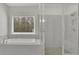 Elegant bathroom with large soaking tub, marble wall and glass shower at 399 Tillman Pass, Woodstock, GA 30188