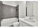 Modern bathroom boasts gray tiled shower, white tub, toilet, and sleek vanity at 399 Tillman Pass, Woodstock, GA 30188