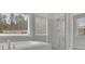 Bright bathroom featuring a soaking tub, large window, and glass enclosed shower at 399 Tillman Pass, Woodstock, GA 30188
