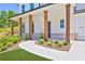 Inviting front porch with wooden columns, gray brick accents and manicured landscaping at 399 Tillman Pass, Woodstock, GA 30188