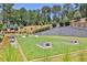 Community game space featuring a cornhole and a lawn area with retaining wall and plenty of room to play at 399 Tillman Pass, Woodstock, GA 30188