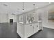 Open kitchen featuring a granite island with a sink, white cabinets, and stainless appliances at 399 Tillman Pass, Woodstock, GA 30188