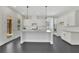 Modern kitchen featuring white cabinets, a granite island, stainless appliances, and a rear patio entrance at 399 Tillman Pass, Woodstock, GA 30188
