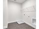 Tiled laundry room featuring a utility sink, washer hookups, and a storage shelf at 399 Tillman Pass, Woodstock, GA 30188