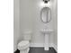 Contemporary powder room featuring a pedestal sink, modern fixtures, and dark hardwood floors at 399 Tillman Pass, Woodstock, GA 30188