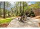 Expansive backyard featuring mature trees, lush greenery, a stone patio, firepit, and fenced perimeter for privacy at 883 Wildwood Ne Rd, Atlanta, GA 30324