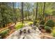 Serene backyard with a stone patio, outdoor dining area, grill, and lush landscaping offering privacy and tranquility at 883 Wildwood Ne Rd, Atlanta, GA 30324