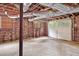 Unfinished basement area with a garage door and exposed brick walls at 883 Wildwood Ne Rd, Atlanta, GA 30324