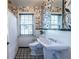 Charming bathroom featuring unique black and white patterned wallpaper, a pedestal sink, and a tiled floor at 883 Wildwood Ne Rd, Atlanta, GA 30324