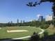 A lovely shot of a grassy city park with walking trails, volleyball court, and city views against a bright blue sky at 883 Wildwood Ne Rd, Atlanta, GA 30324